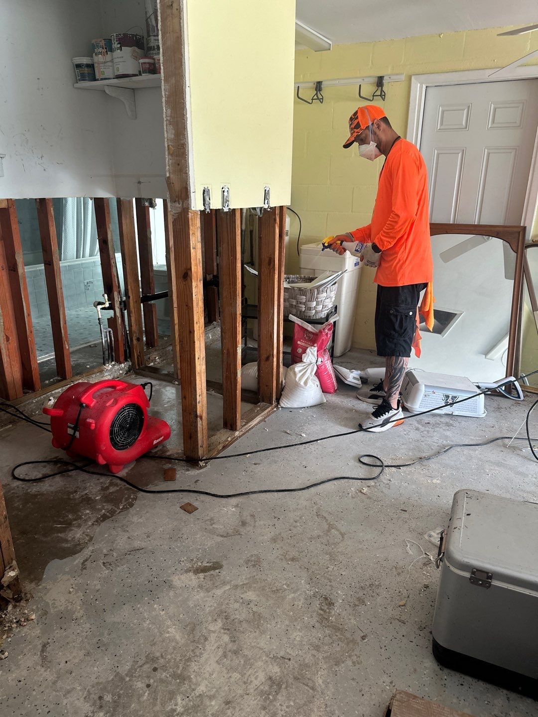 Crew member working beside air movers in a flood damaged room