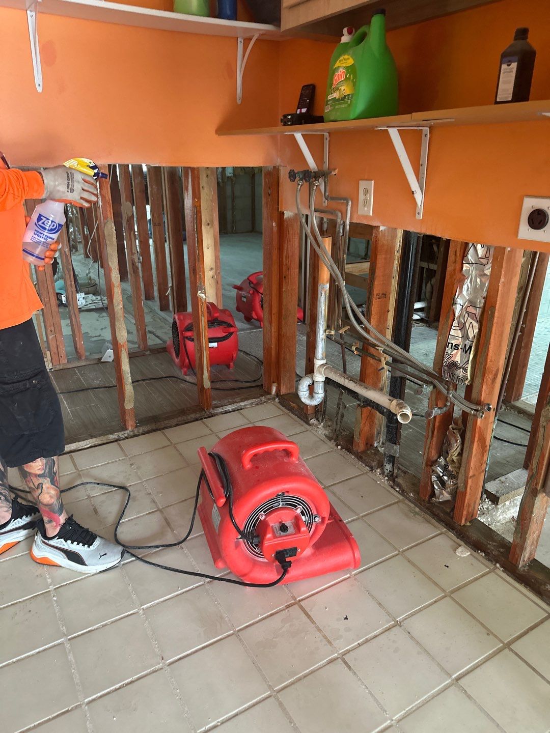 Restoration crew inspecting exposed framing and drying equipment