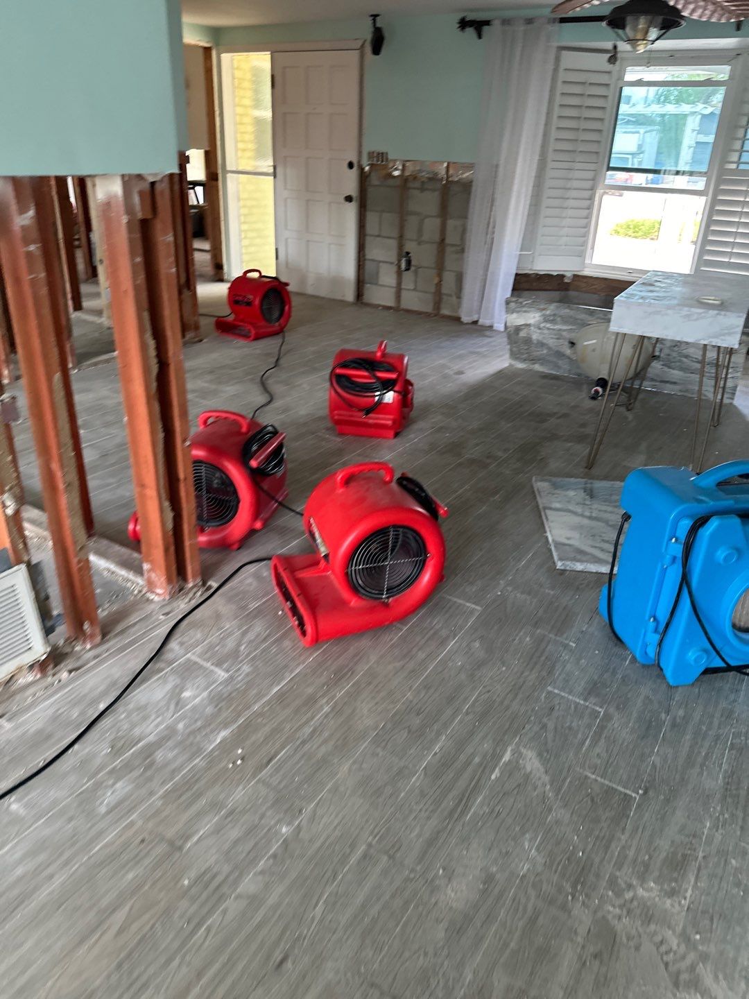 Air movers drying exposed framing and floors