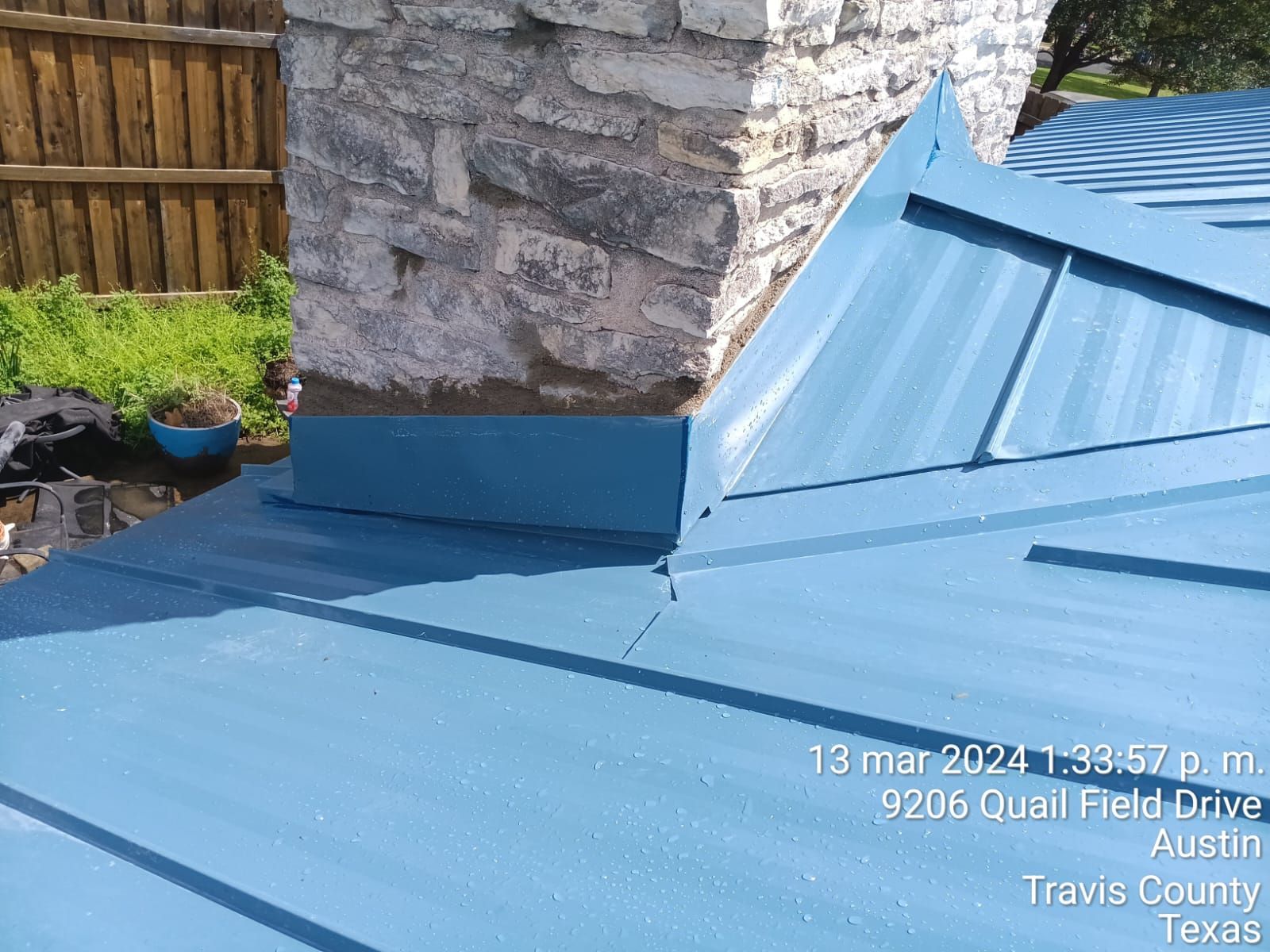 Metal roof panels meeting chimney flashing, Big Texas Roofing and Solar