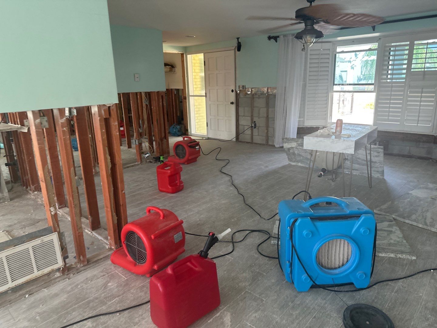 Air movers and drying equipment beside exposed wall framing