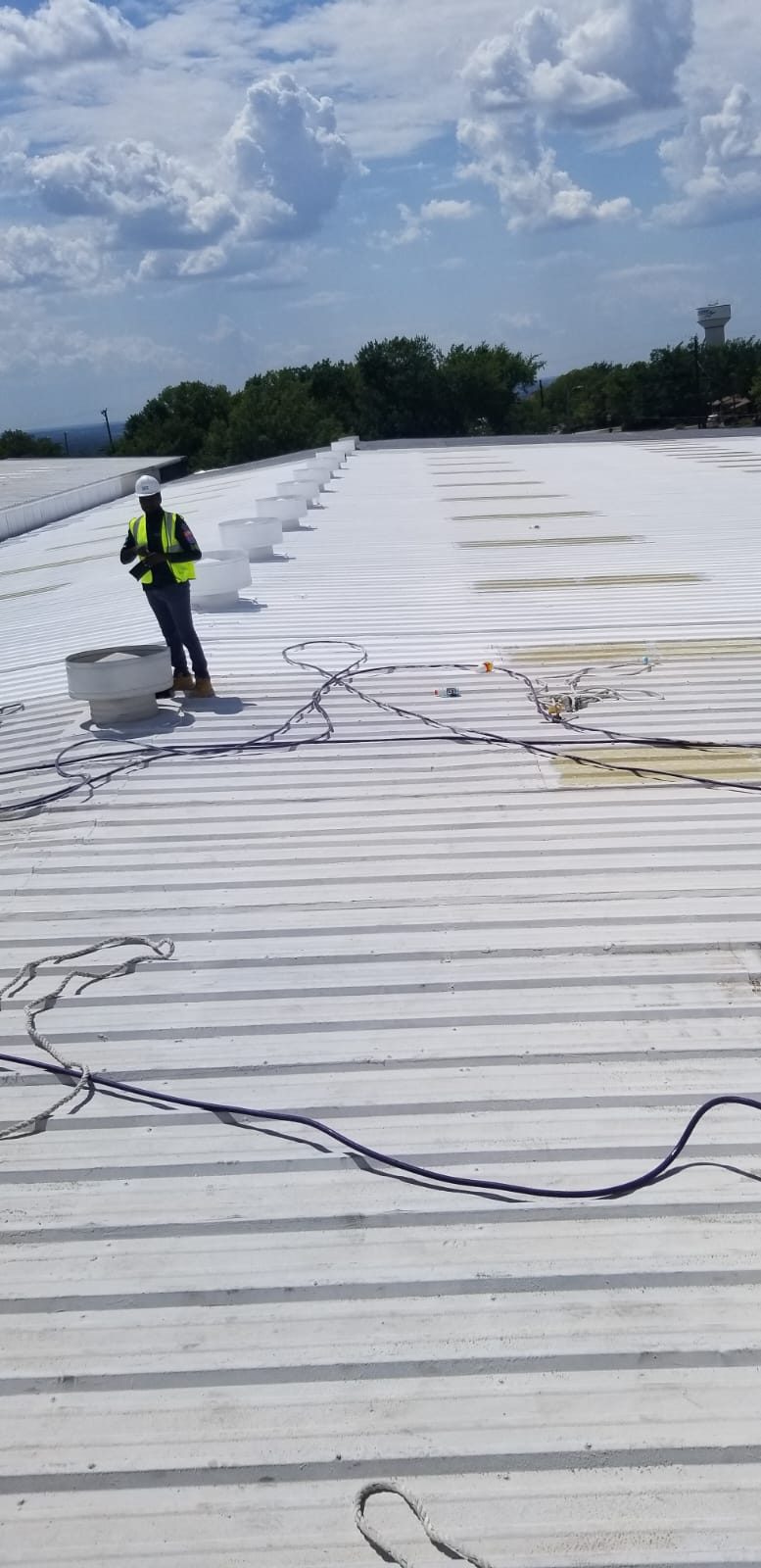 Inspector walking a freshly coated metal roof in Denver Colorado